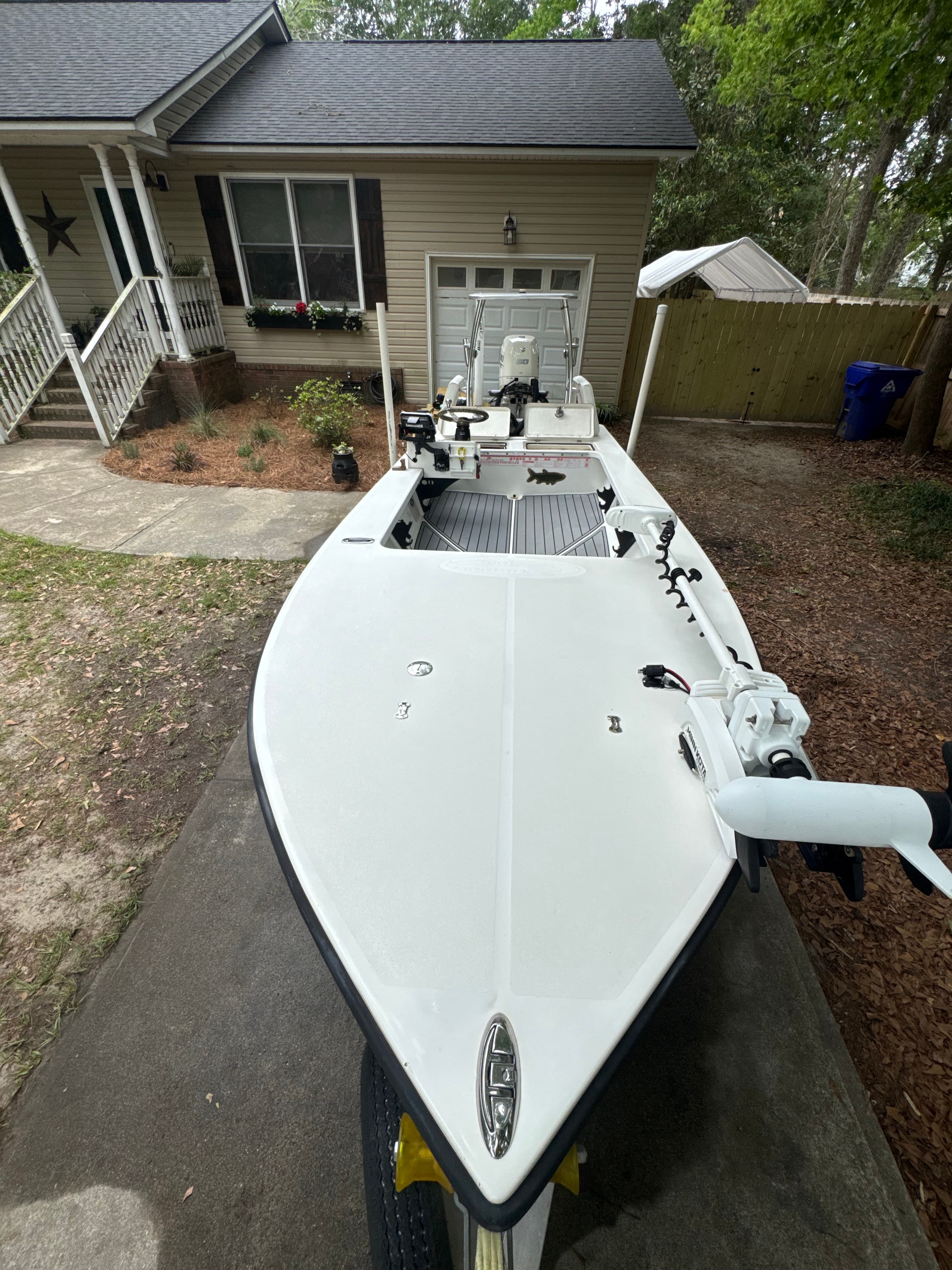 Mobile boat detailing in Charleston, SC, a center console at a harbor slip with chalky gelcoat oxidation and rust-colored waterline staining being polished back to gloss.